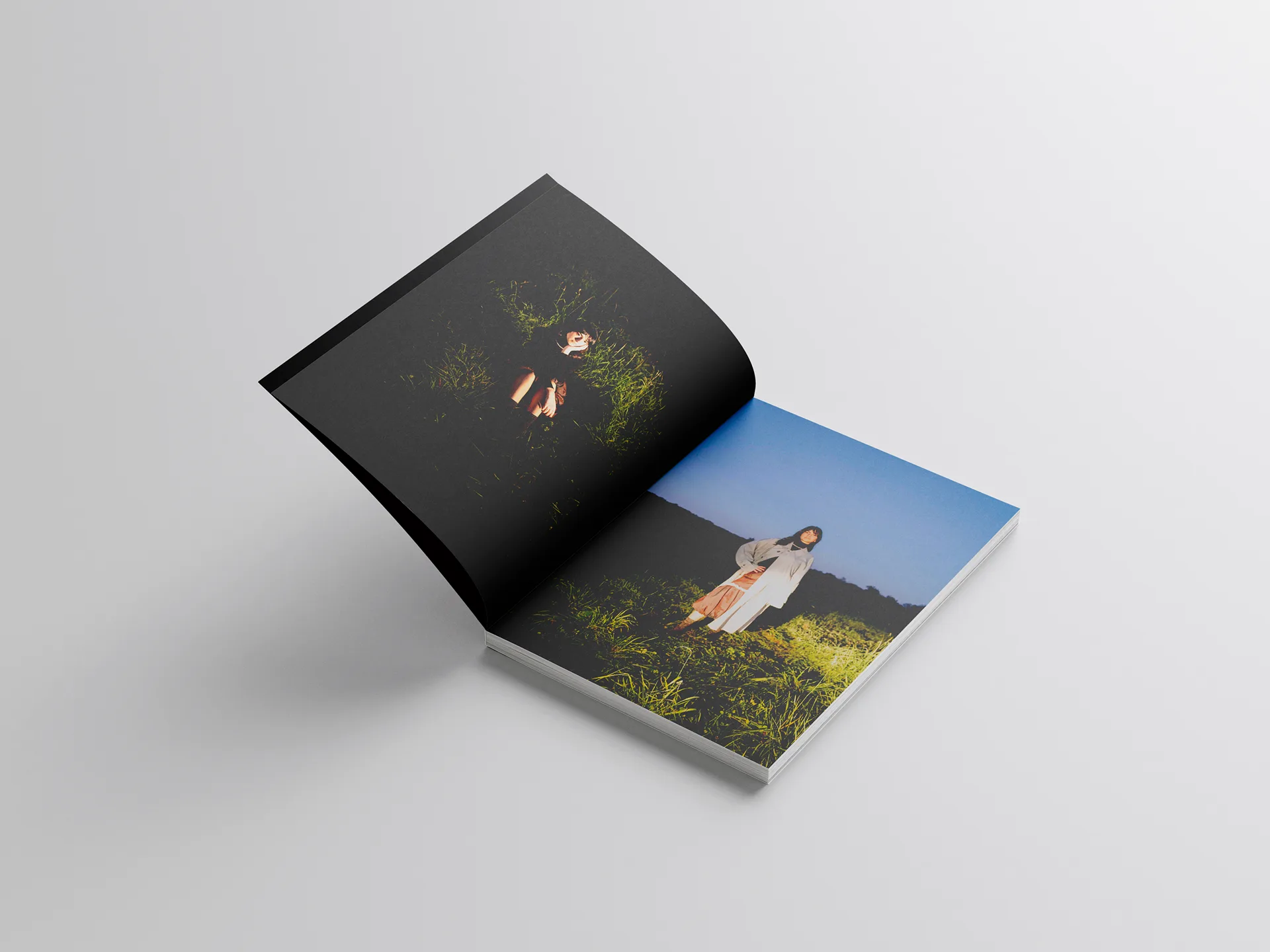 Book aperto sullo scatto della modella in un prato illuminato dal sole